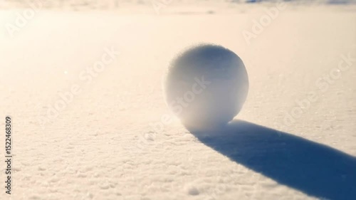 A snowball rolls through the snow