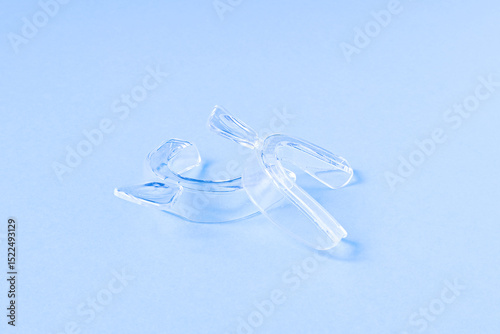 Transparent silicone dental mouth guards for teeth. Light blue background. photo