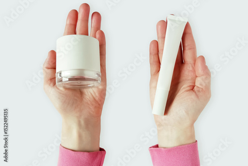 Face cream in a glass jar and eye cream in a white tube on the palms of a Caucasian woman. White background.