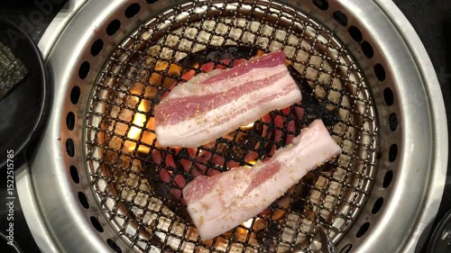 Meat slides are gilling on electric stove in bbq Korean restaurant 