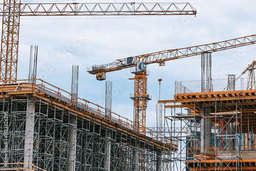 Construction site photography: towering cranes, steel reinforcement, and structural frameworks define this urban development scene. No people present-ideal for architectural and infrastructure project