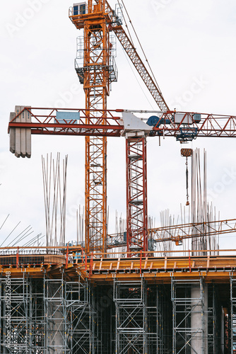 Construction site photography: towering cranes, steel reinforcement, and structural frameworks define this urban development scene. No people present-ideal for architectural and infrastructure project