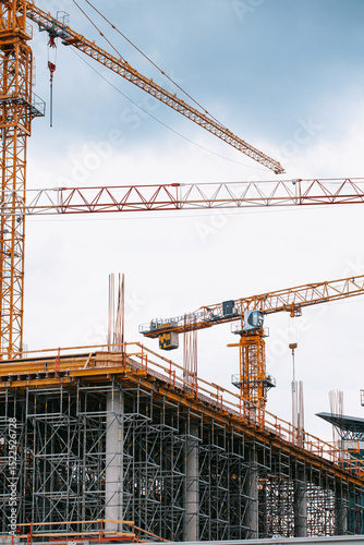 Construction site photography: towering cranes, steel reinforcement, and structural frameworks define this urban development scene. No people present-ideal for architectural and infrastructure project
