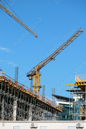 Construction site photography: towering cranes, steel reinforcement, and structural frameworks define this urban development scene. No people present-ideal for architectural and infrastructure project