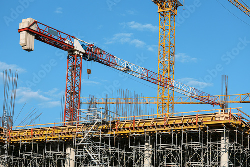 Construction site photography: towering cranes, steel reinforcement, and structural frameworks define this urban development scene. No people present-ideal for architectural and infrastructure project