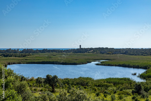 Ancient lagoon landscape stretching to the sea, with lakes, dunes and restored Lycian lighthouse. Historical harbor area of Patara. Mediterranean, Turkey. photo