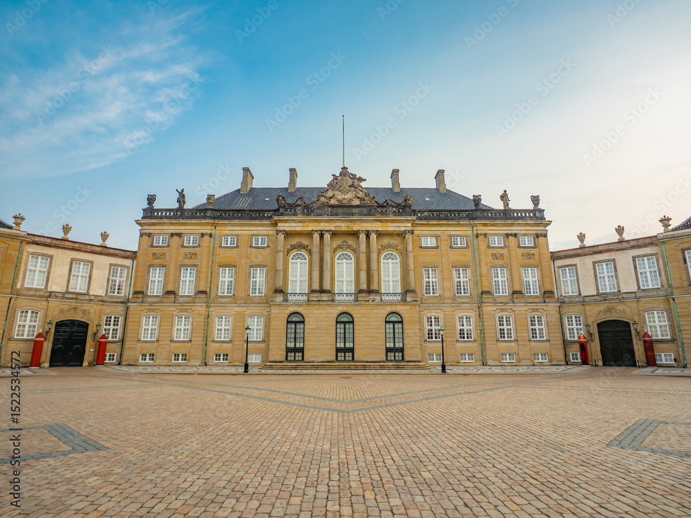 Obraz premium Levetzau's Palace (Christian VIII's Palace) in Amalienborg, Copenhagen—classic neoclassical architecture with a grand courtyard under a bright blue summer sky.