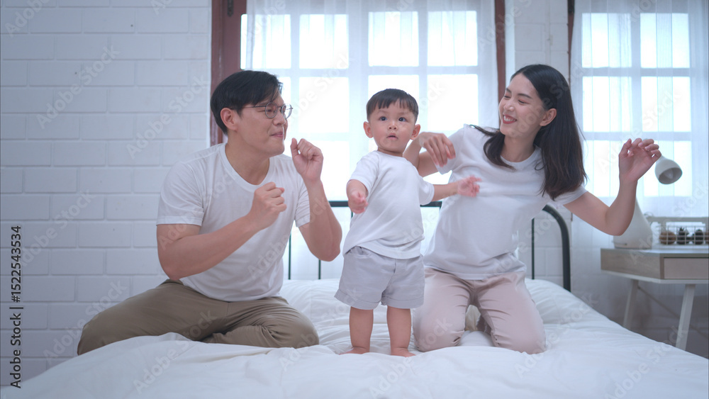 Fototapeta premium Before putting the kids to bed, parents, and kid unwind and play in the bedroom