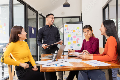 Group of happy asian businesspeople celebrate project brainstorm at modern office.