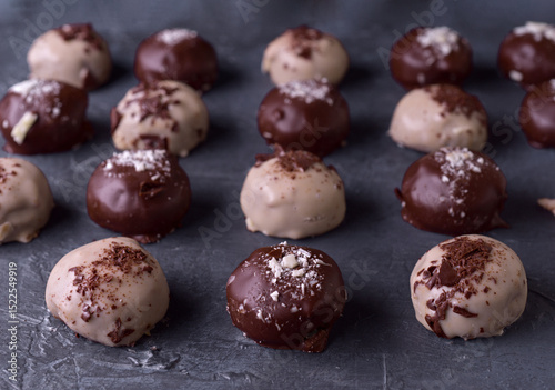 Assorted chocolate truffles on a dark slate background