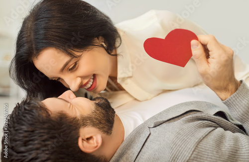 Close up shot of a happy married couple celebrates Valentine Day by embracing on the floor. Love, affection, and togetherness are evident as they share happiness and romance during the celebration.