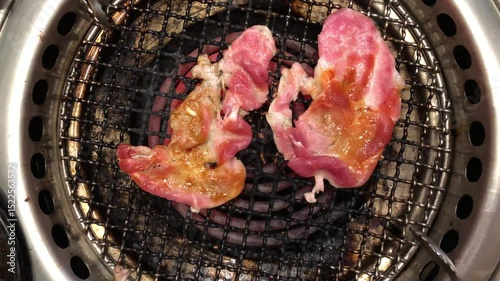 Meat slides are gilling on electric stove in bbq Korean restaurant 