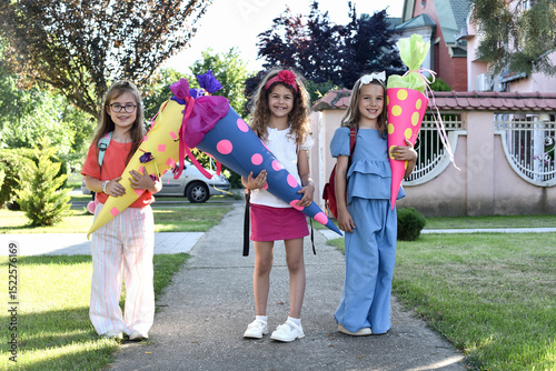Happy little children with sweets in a cone on the first day of school. Back to school