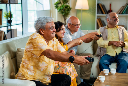 Obraz na plátne Seniors enjoy friendly gaming session during relaxed get-together at cozy modern