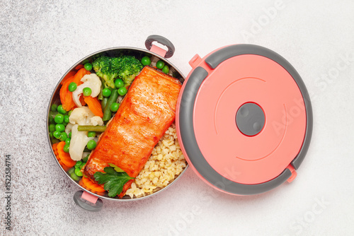 Salmon fillets with bulgur and vegetables in the container. Diet nutrition. Top view
