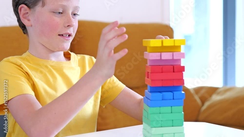 A child engages joyfully with a vibrant stacking game, demonstrating skill and concentration in a bright, inviting space.
