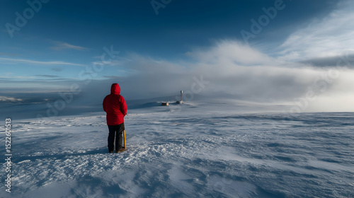 Exploring the serene winter landscape while observing a distant lighthouse amidst swirling clouds and snow at a high altitude