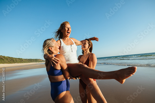 Friends enjoying vacation together on the beach at sunset celebrating joy
