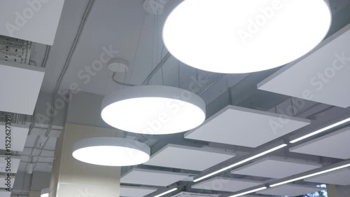 Circular LED lights decorate geometric ceiling with futuristic elegance. Patterns and symmetry create artistic, modern atmosphere