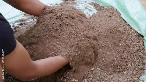 gardener hand mixing organic soil for plantation at outdoor