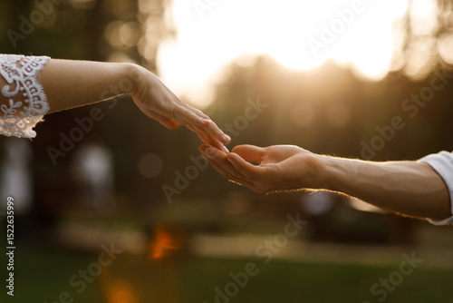 hands of romantic couple a close-up. hands men and women symbol love teamwork sunlight happy family together. silhouette hands support stroking each other. dating, romantic atmosphere