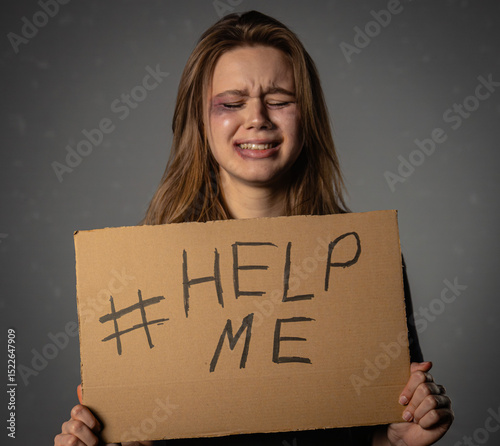 Crying Woman Holding Help Me Sign Against Grey Background