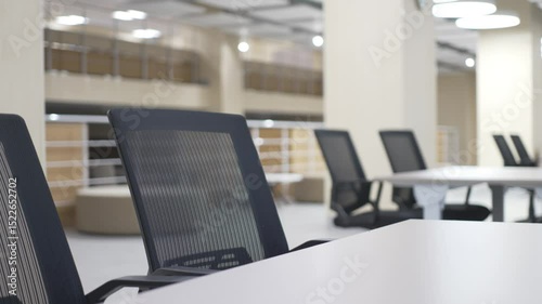 Dark chairs contrast with cream-colored tables in cozy bright university canteen. Color harmony enhances visual comfort and elegance