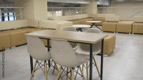 Spacious lounge features soft oversized sofas and cozy chairs arranged near small tables. Calm lighting offer warm peaceful atmosphere
