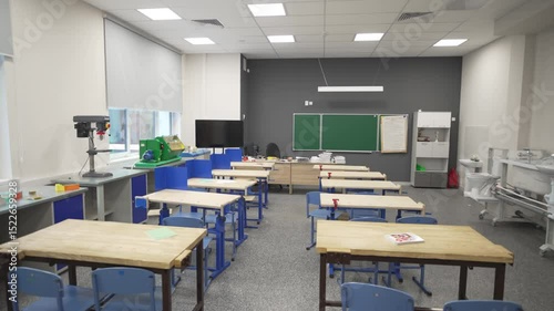 Modern classroom features sleek TV and advanced projector enhancing interactive learning. Ergonomic furniture create inviting atmosphere