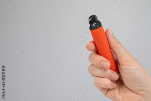 Woman holding disposable vape on white background. Copy space. 