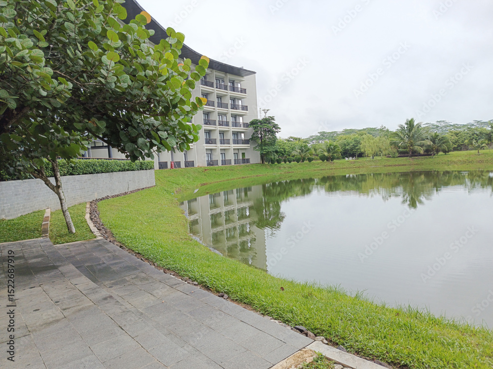 Fototapeta premium Serene Lakeside View with Modern Building and Greenery