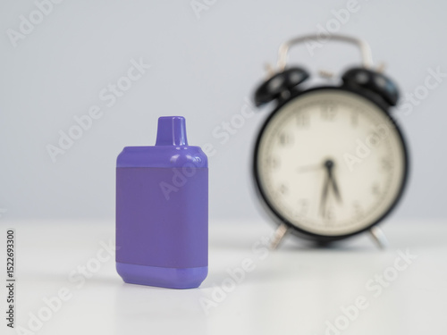 Disposable vape and alarm clock on white background. 