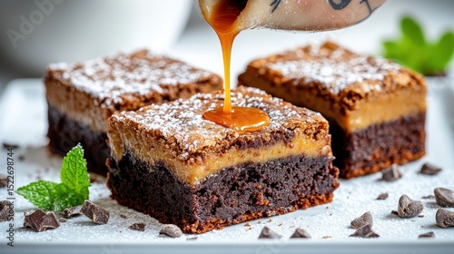 Chef pouring caramel sauce on delicious brownie with icing sugar and chocolate chips photo