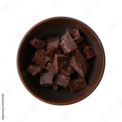 Top view of chopped dark chocolate pieces in a rustic ceramic bowl, isolated on black background