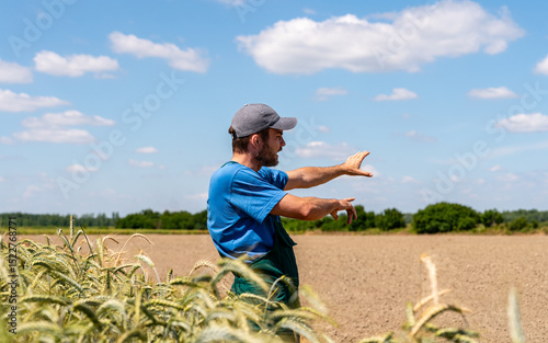 Farmer discussing crop plans while pointing in field