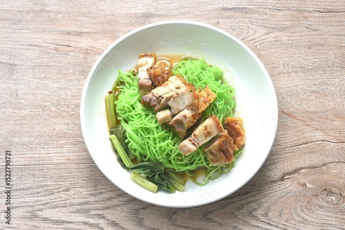 Chinese jade noodles topping roasted crispy pork dipping sweet soy sauce on plate 