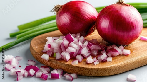 Chopped red onions are arranged aesthetically on a wooden board, emphasizing their culinary versatility and vibrant color for enhancing dishes.