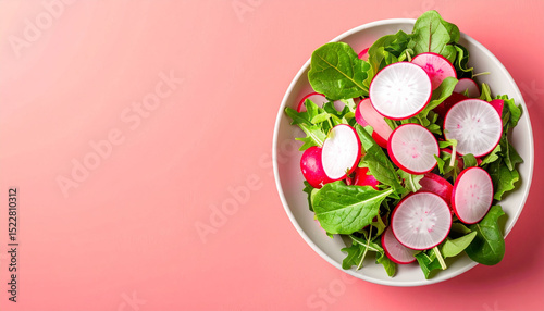 a vibrant salad is presented in a simple, round bowl. the salad consists of green leafy vegetables and sliced root vegetables with a red skin and white flesh