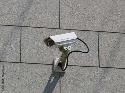 Fotografie A surveillance camera is attached to the wall of the bank,
monitoring surrounding area for security