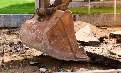 Excavator removing pavement at a construction site