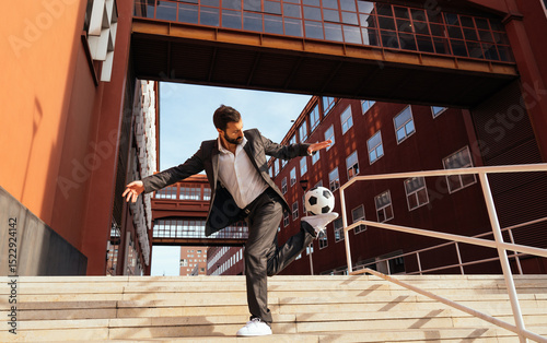 Businessman playing with a soccer ball and making freestyle tricks