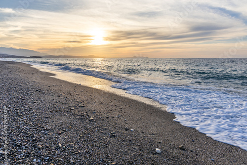 Fototapeta Naklejka Na Ścianę i Meble -  Beautiful coastline with a sandy and pebble beach at sunset. Beautiful sky coloration in the tourist and hotel area of ​​Platanes Beach, Rethymno, Crete, Greece