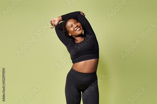 Young fit african american sportswoman stretches in a bright studio setting