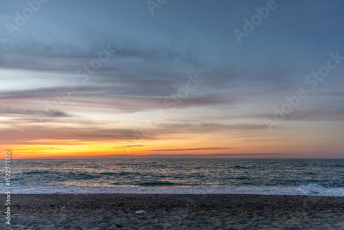 Fototapeta Naklejka Na Ścianę i Meble -  Beautiful coastline with a sandy and pebble beach at sunset. Beautiful sky coloration in the tourist and hotel area of ​​Platanes Beach, Rethymno, Crete, Greece