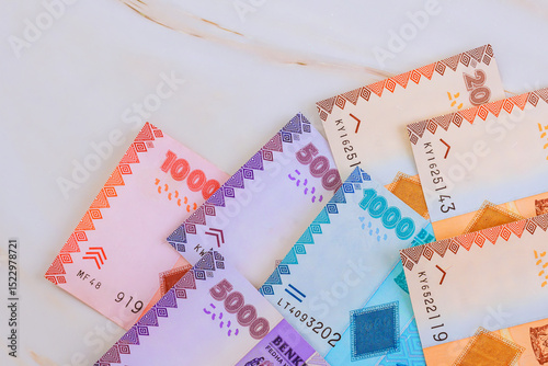 Tanzanian shilling banknotes lay on marble, showcasing various values intricate designs for visual appeal.