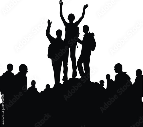 Silhouette of hikers celebrating reaching the summit with others watching below
