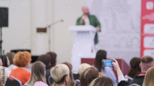 Audience paying attention at a live business presentation during an event, showcasing focus.