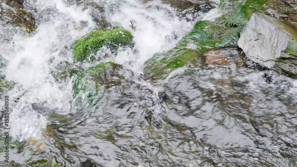 rapid flow of water in river among stones close-up, slow motion
