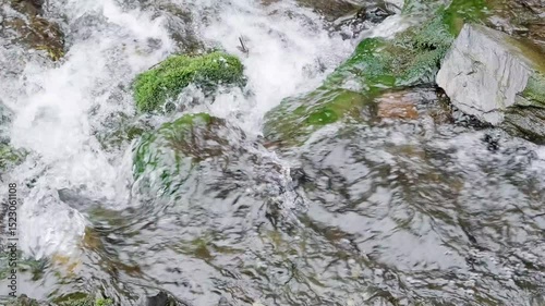 rapid flow of water in river among stones close-up, slow motion
