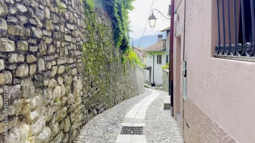 Como, Italy - May 3 2025 : Narrow cobbled alleys and colorful old houses in the historic villages of Ossuccio and Lenno, Lake Como, Italy, with stone walls, arches, balconies and Mediterranean charm